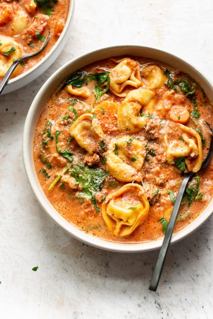 Crockpot tortellini spinach soup with sausage in two bowls