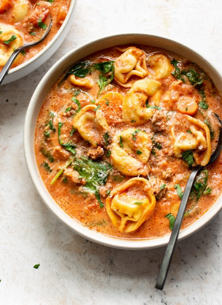 Crockpot tortellini spinach soup with sausage in two bowls