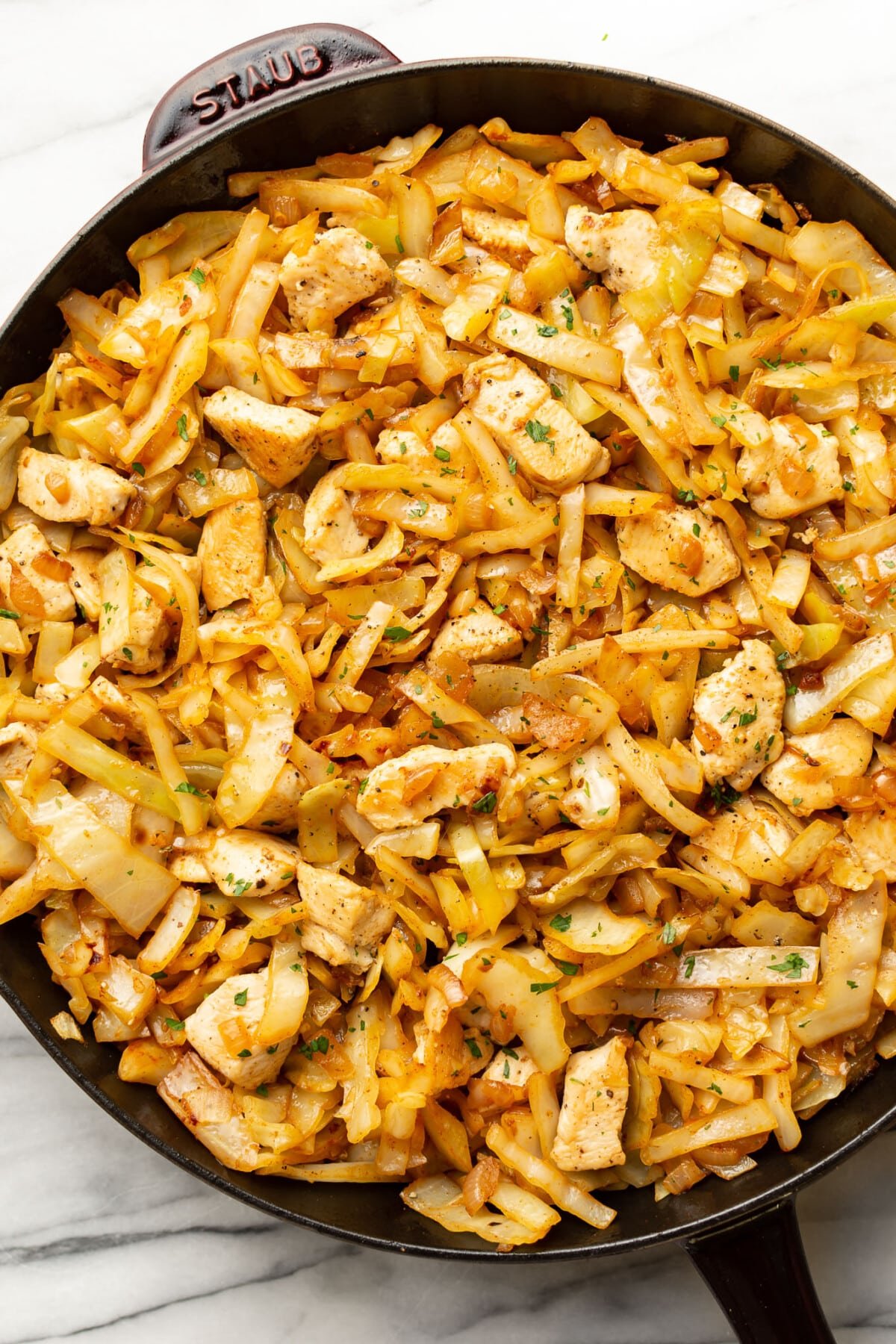 a skillet with chicken and cabbage stir fry