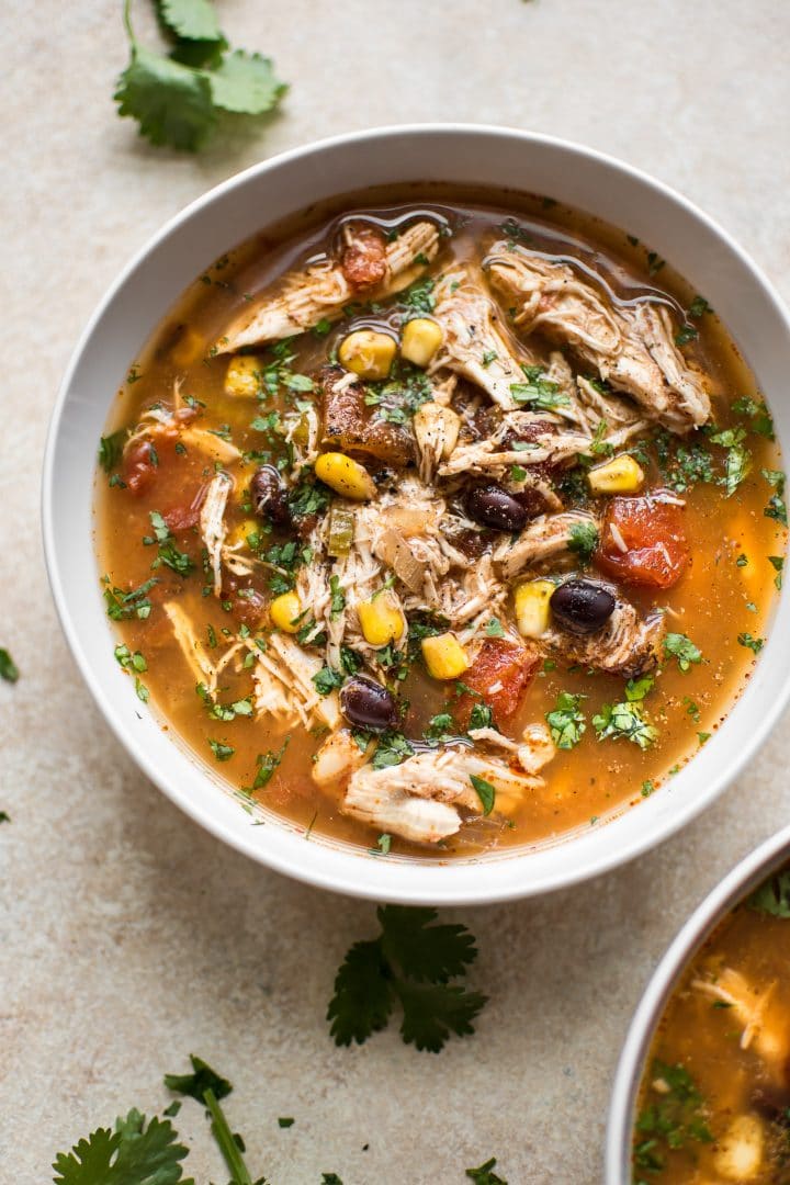 white bowl with easy Crockpot chipotle chicken soup with corn, black beans, fire-roasted tomatoes, and chipotle chili peppers