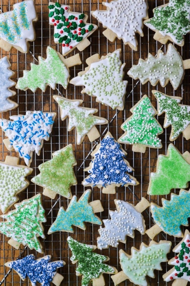 several christmas tree shaped holiday sugar cookies with DIY colored sugar on a wire rack