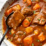 a bowl of instant pot beef stew with a spoon