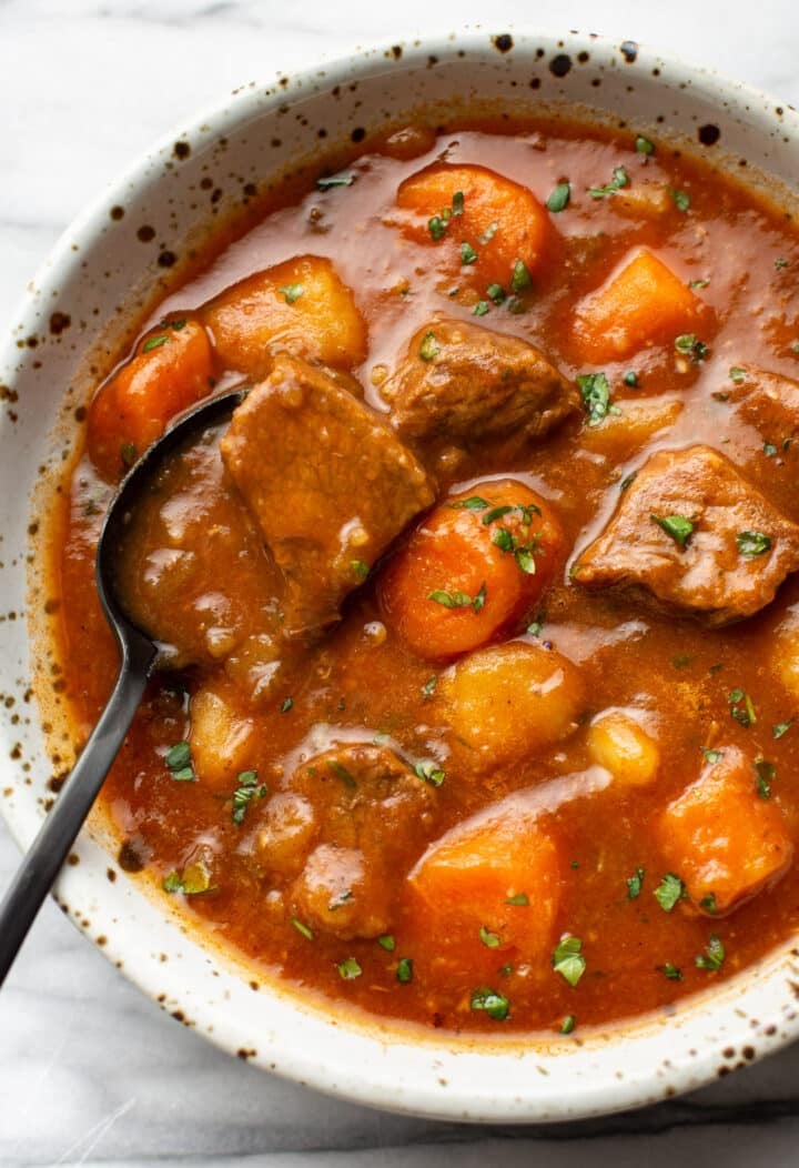 a bowl of instant pot beef stew with a spoon