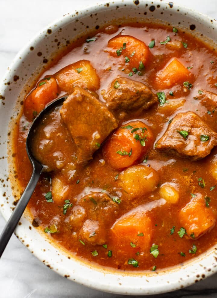 a bowl of instant pot beef stew with a spoon