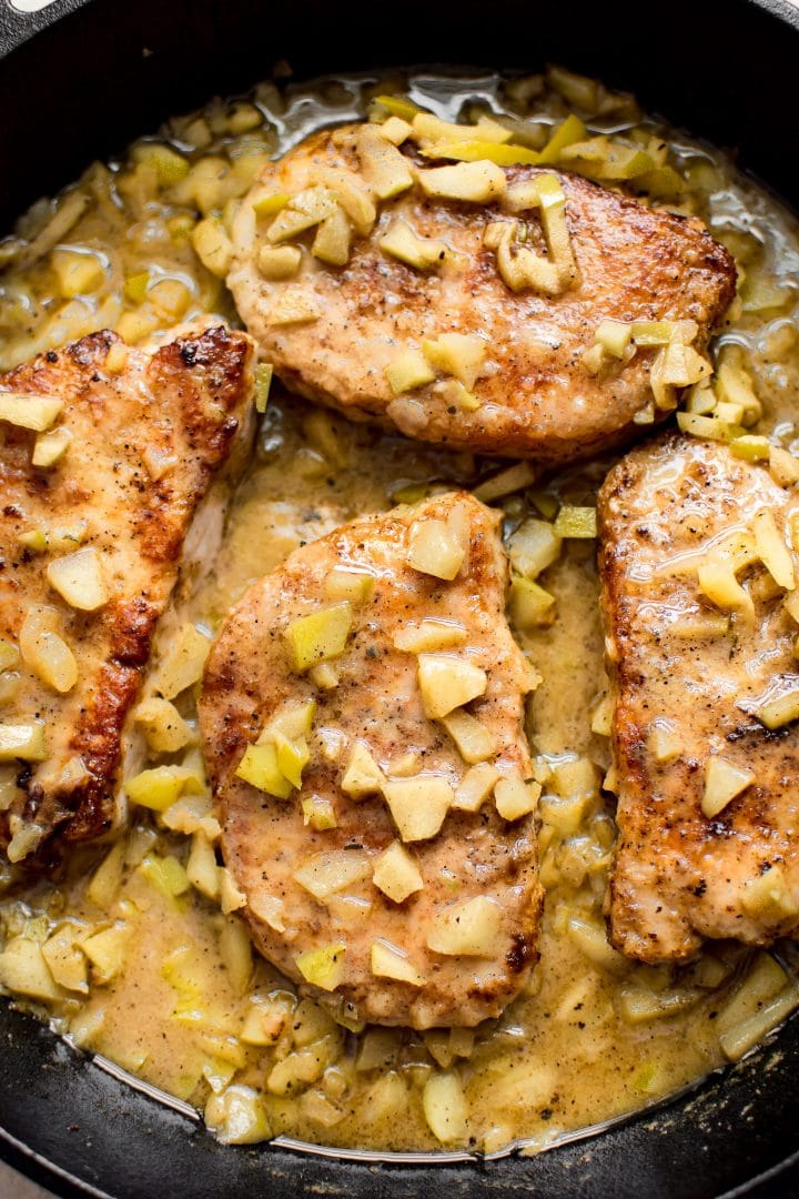 close-up of pork with chopped apples and butter in a skillet