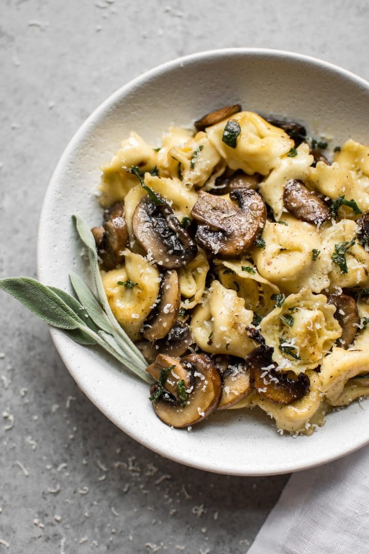 tortellini with sage butter sauce in a white bowl