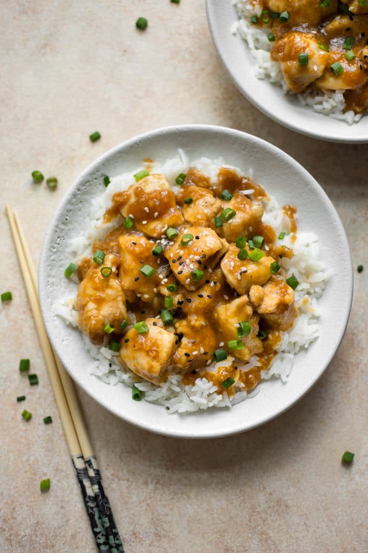 two bowls of mongolian chicken beside chopsticks