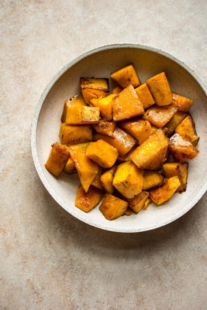 honey roasted butternut squash in a beige bowl