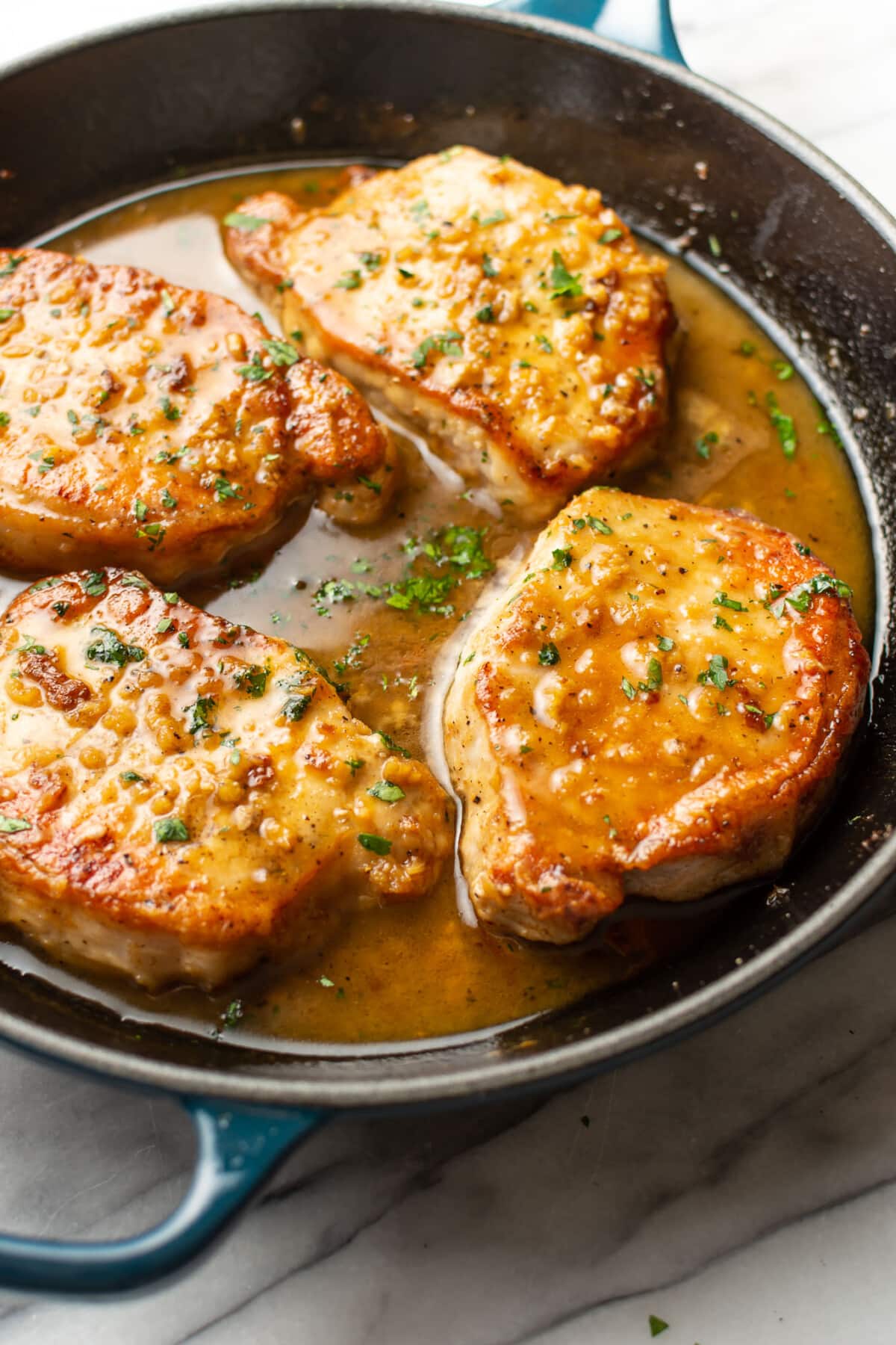 a skillet with honey soy sauce pork chops