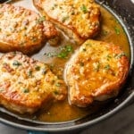 a skillet with honey soy sauce pork chops