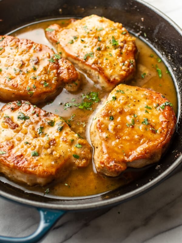 a skillet with honey soy sauce pork chops
