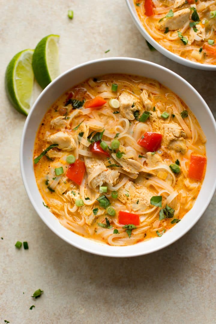 bowl of Thai creamy leftover turkey soup with noodles next to two lime slices