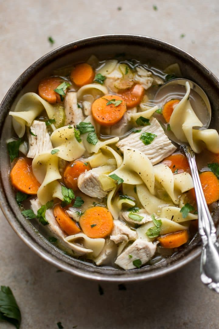 close-up of homemade turkey noodle soup in a bowl with a spoon