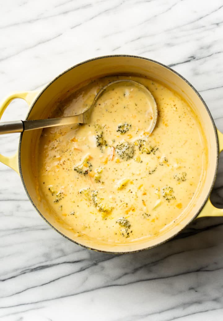 broccoli cheddar soup in a yellow pot with ladle
