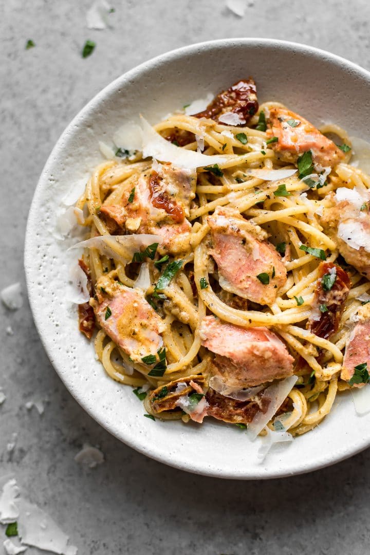 close-up of a bowl of creamy Cajun salmon pasta with grated parmesan cheese