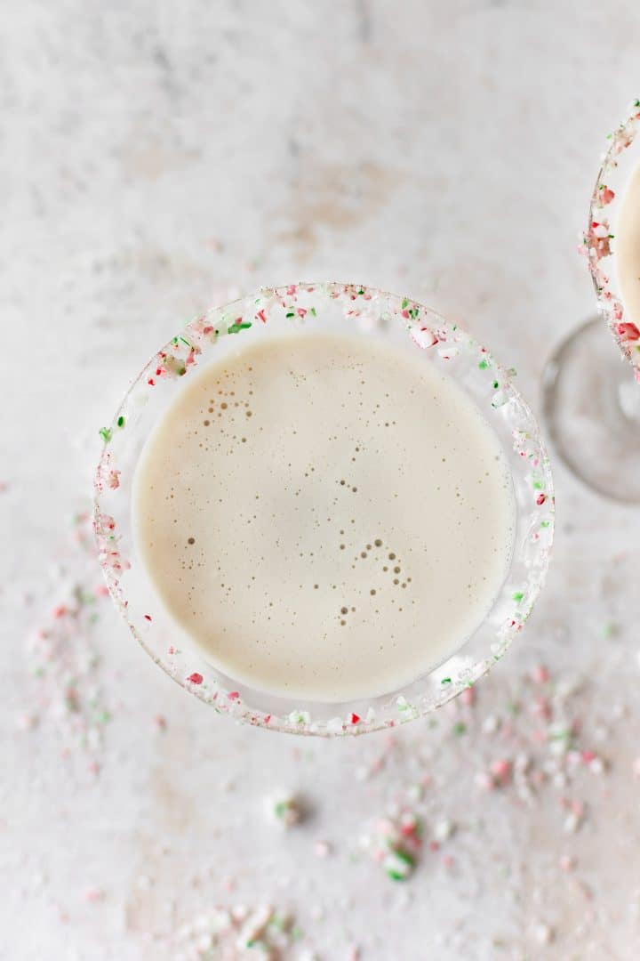 close-up of creamy christmas cocktail with crushed candy cane rim on martini glass