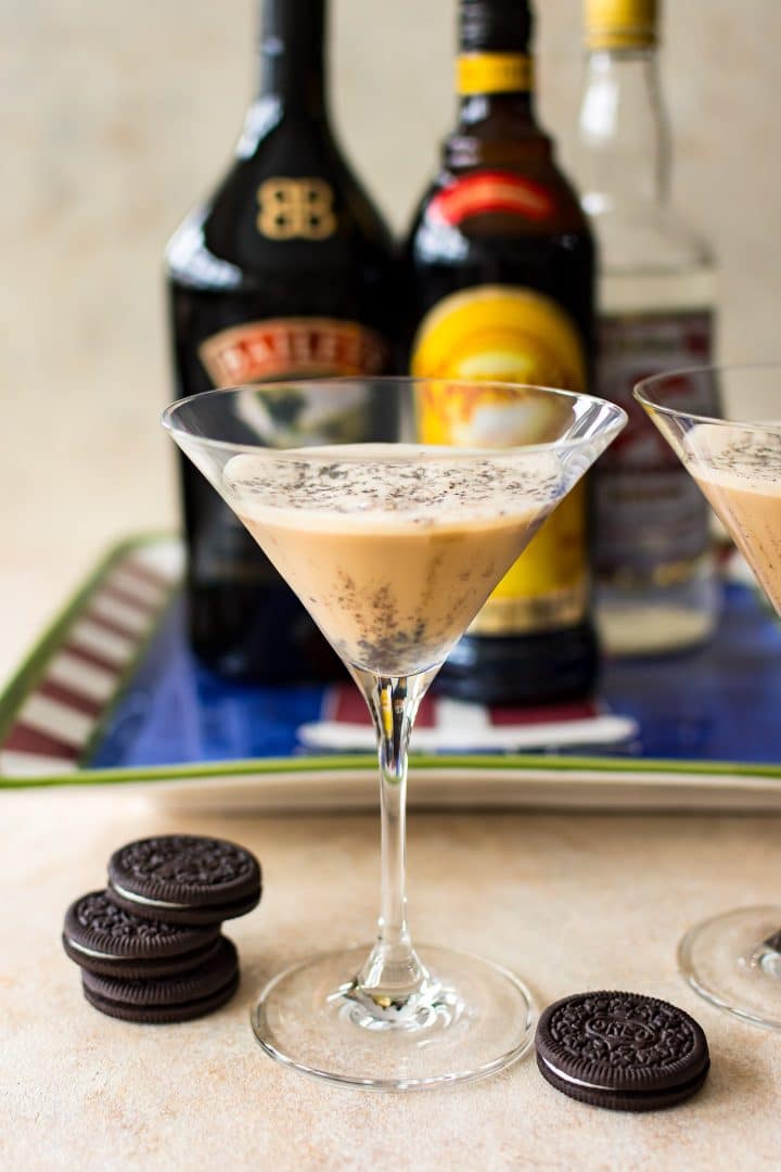 martini class with christmas cookie cocktail next to stack of oreos and bottles of alcohol