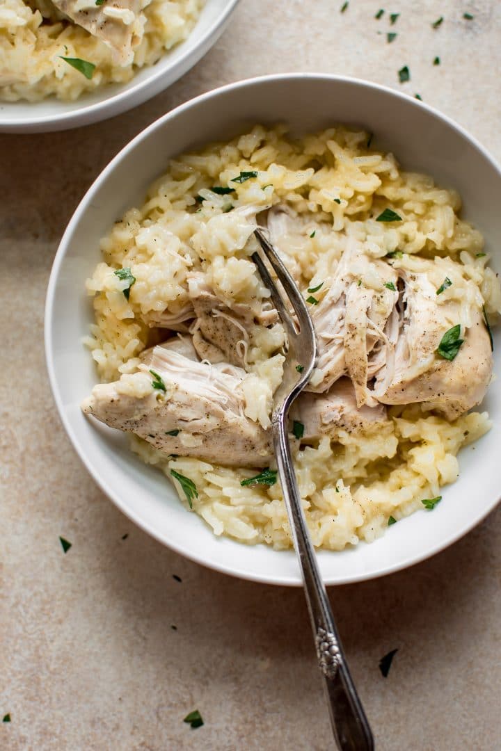 white bowl of tender chicken and rice Instant Pot recipe with a fork