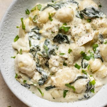 Creamy spinach and artichoke gnocchi is made in one pan, can be made vegetarian, and makes the most delicious comfort food side dish!