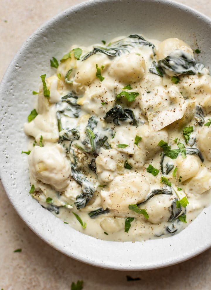 Creamy spinach and artichoke gnocchi is made in one pan, can be made vegetarian, and makes the most delicious comfort food side dish!