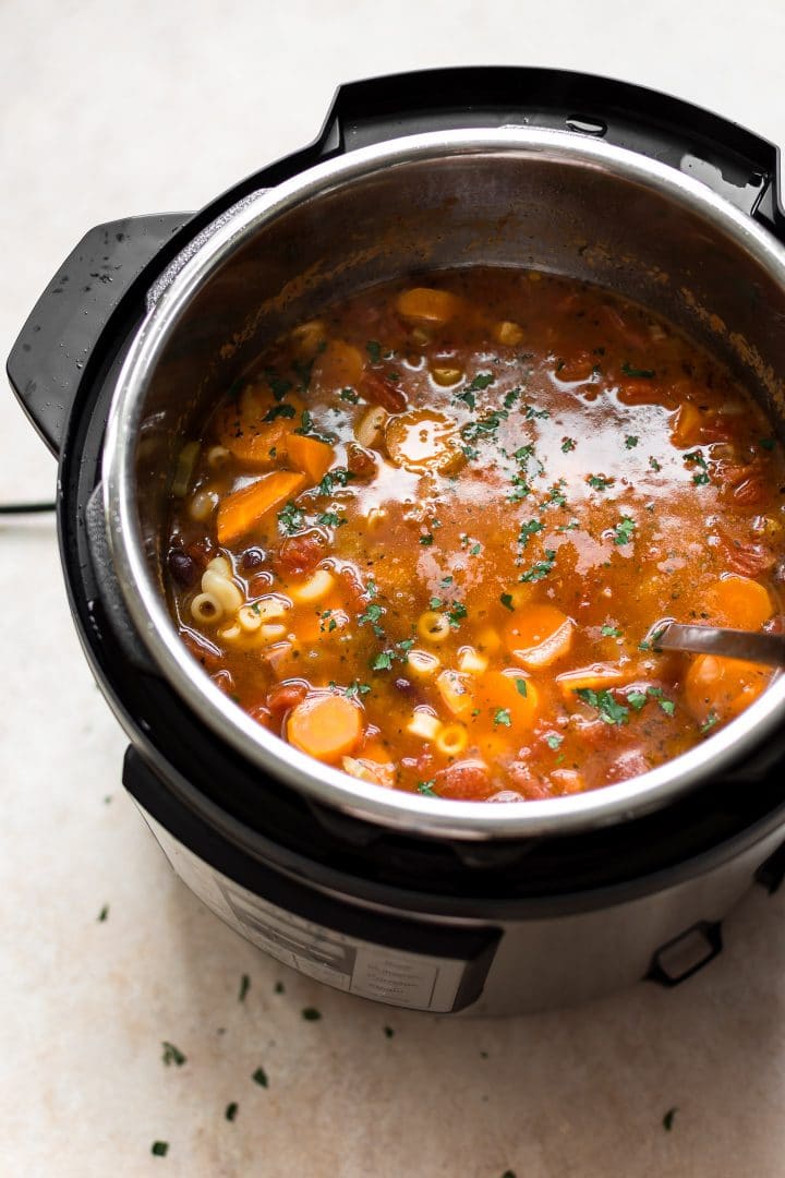 an electric pressure cooker with Instant Pot pasta e fagioli soup and a ladle