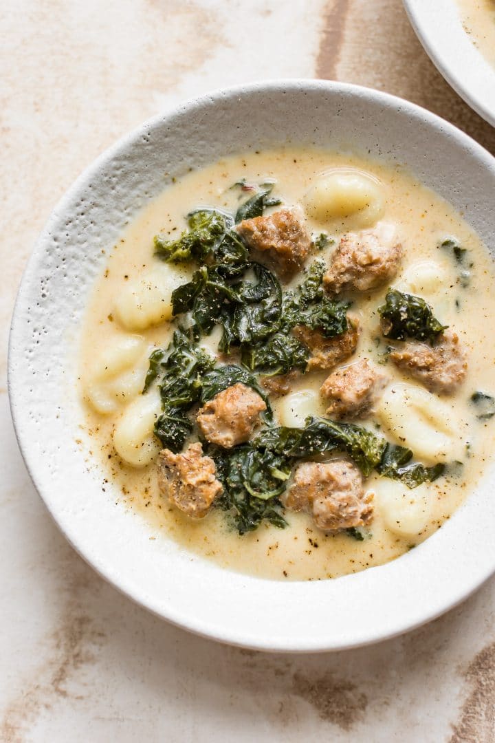 white bowl with easy and creamy gnocchi soup with kale and sausage