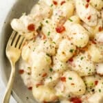 a bowl of chicken bacon gnocchi with a fork