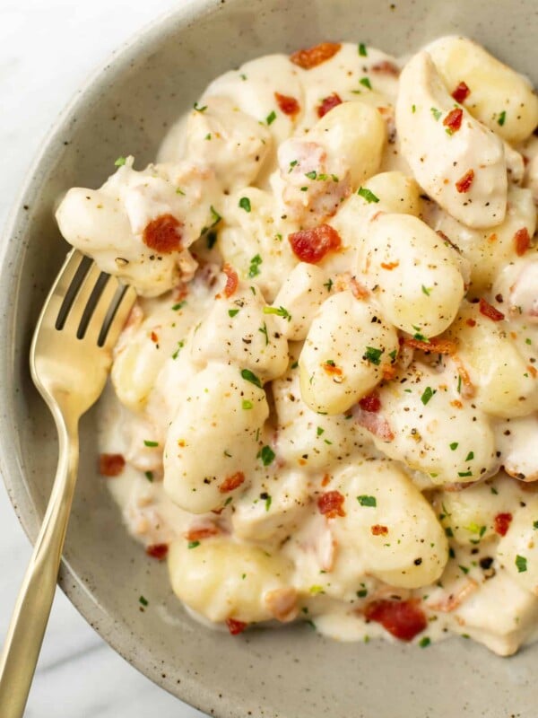 a bowl of chicken bacon gnocchi with a fork