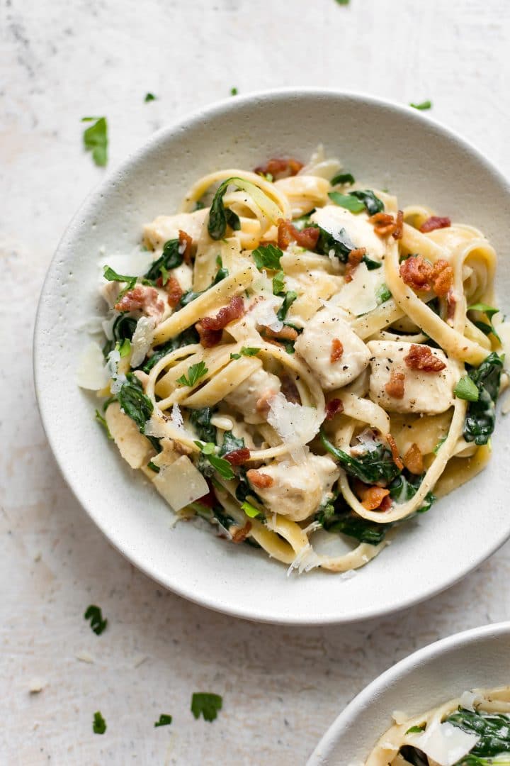 white bowl with spinach bacon chicken pasta