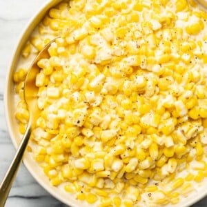 a bowl of creamed corn with a spoon