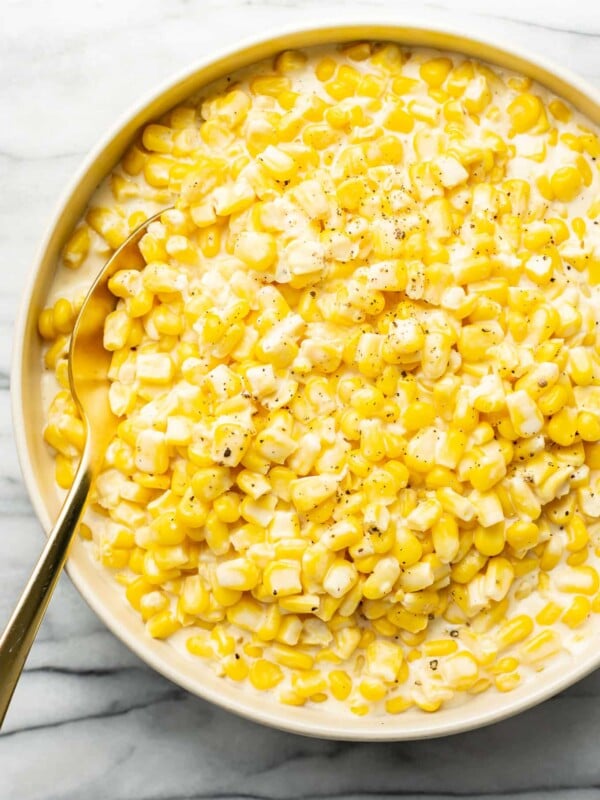 a bowl of creamed corn with a spoon