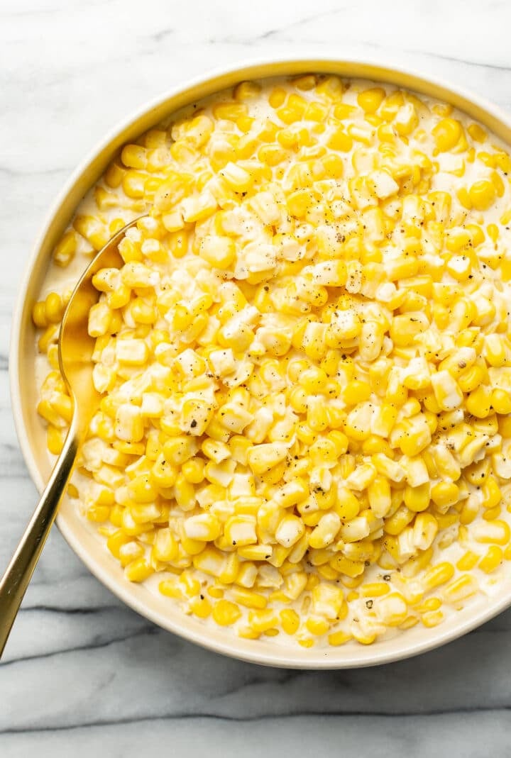 a bowl of creamed corn with a spoon