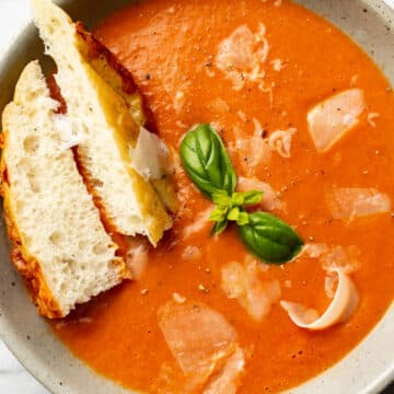 a bowl of tomato soup with bread