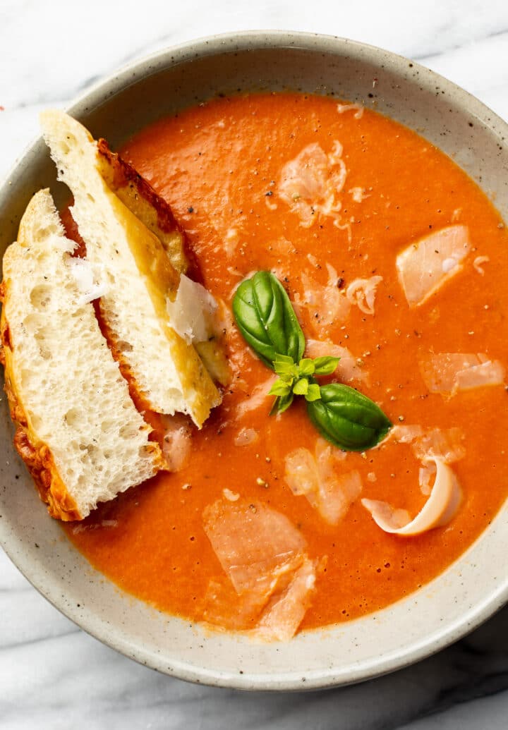 a bowl of tomato soup with bread