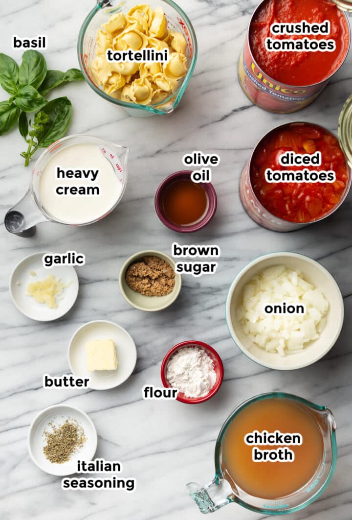 ingredients for tomato tortellini soup in small bowls on a counter