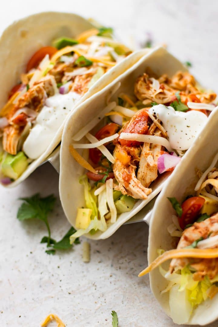 close-up of three Instant Pot shredded chicken tacos with homemade salsa