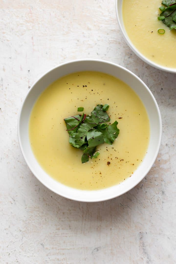 two white bowls with the best potato leek soup