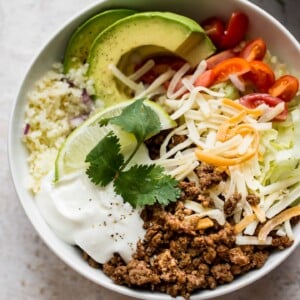 These keto beef taco bowls with cauliflower rice are fast, fresh, and filling. You won't even miss the tortillas!