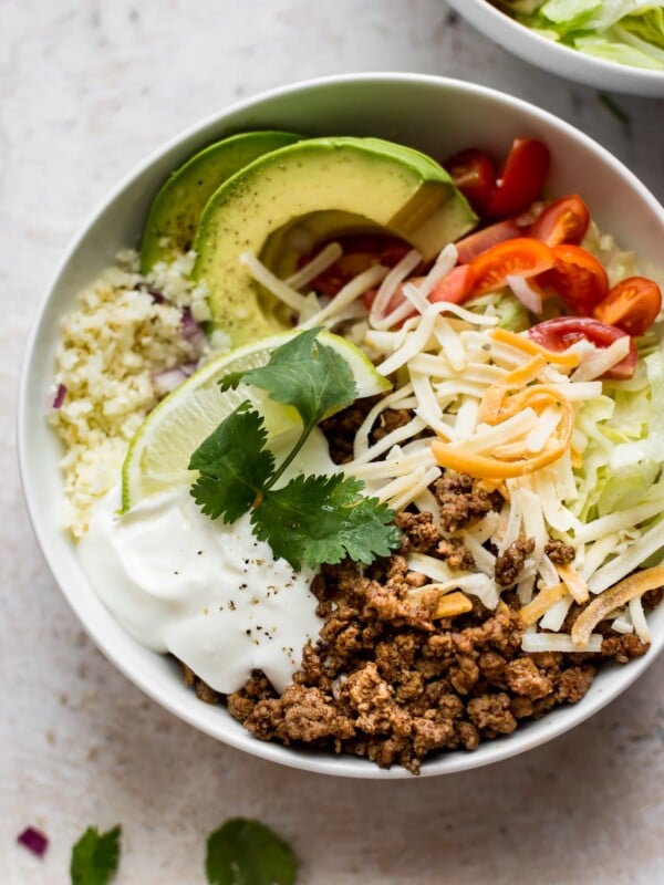 These keto beef taco bowls with cauliflower rice are fast, fresh, and filling. You won't even miss the tortillas!