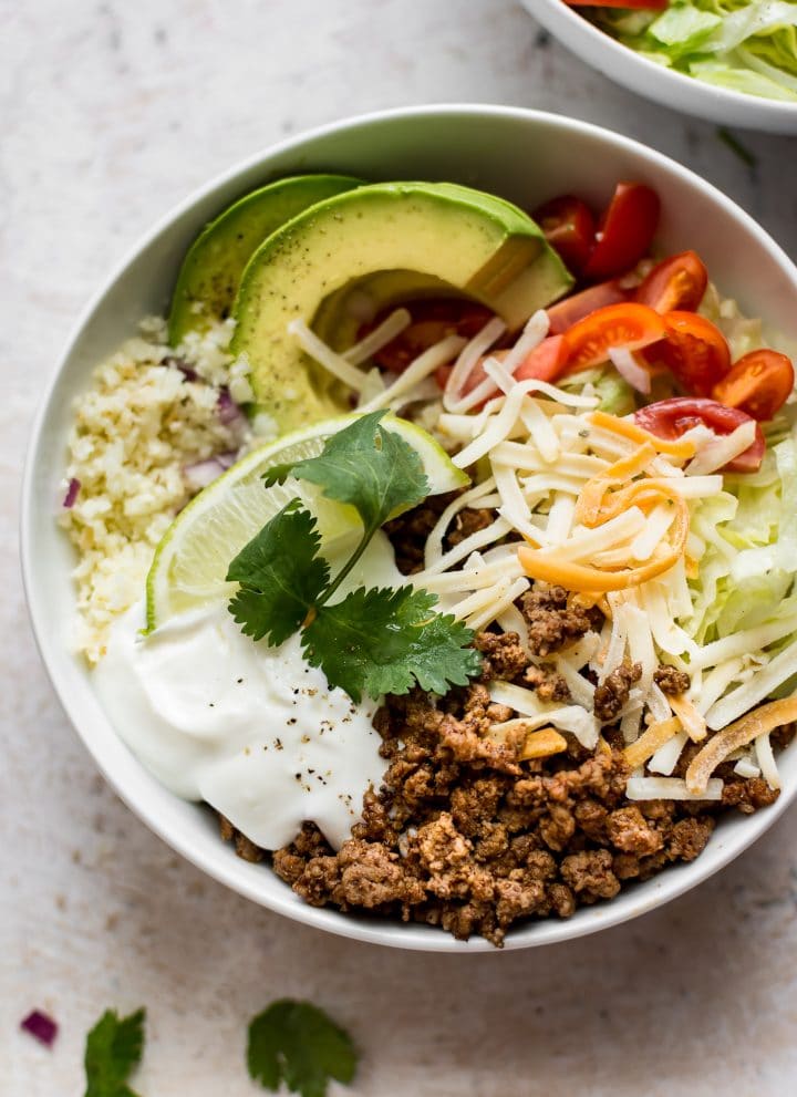 These keto beef taco bowls with cauliflower rice are fast, fresh, and filling. You won't even miss the tortillas!
