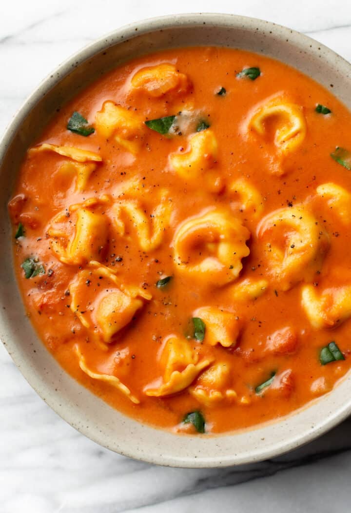 a bowl of tomato tortellini soup