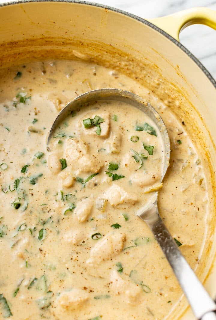 a ladle in a pot of creamy white chicken chili