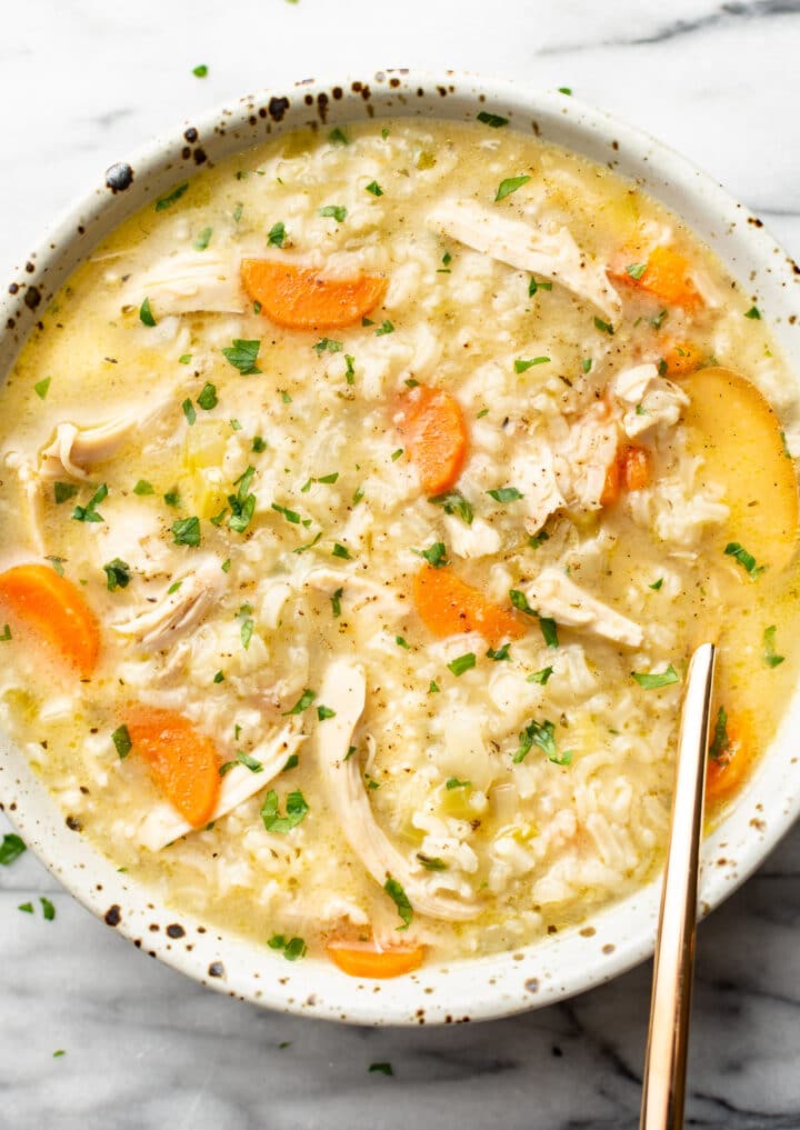 a bowl of chicken and rice soup with a spoon