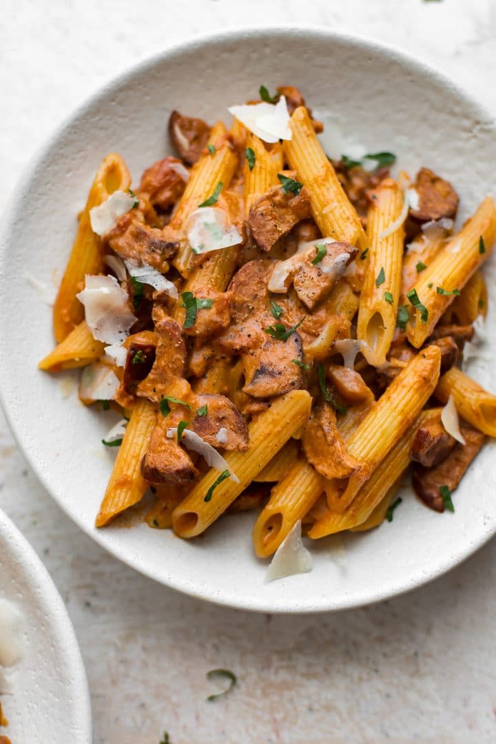 close-up of easy chorizo pasta with a tomato cream sauce served over penne in a white bowl