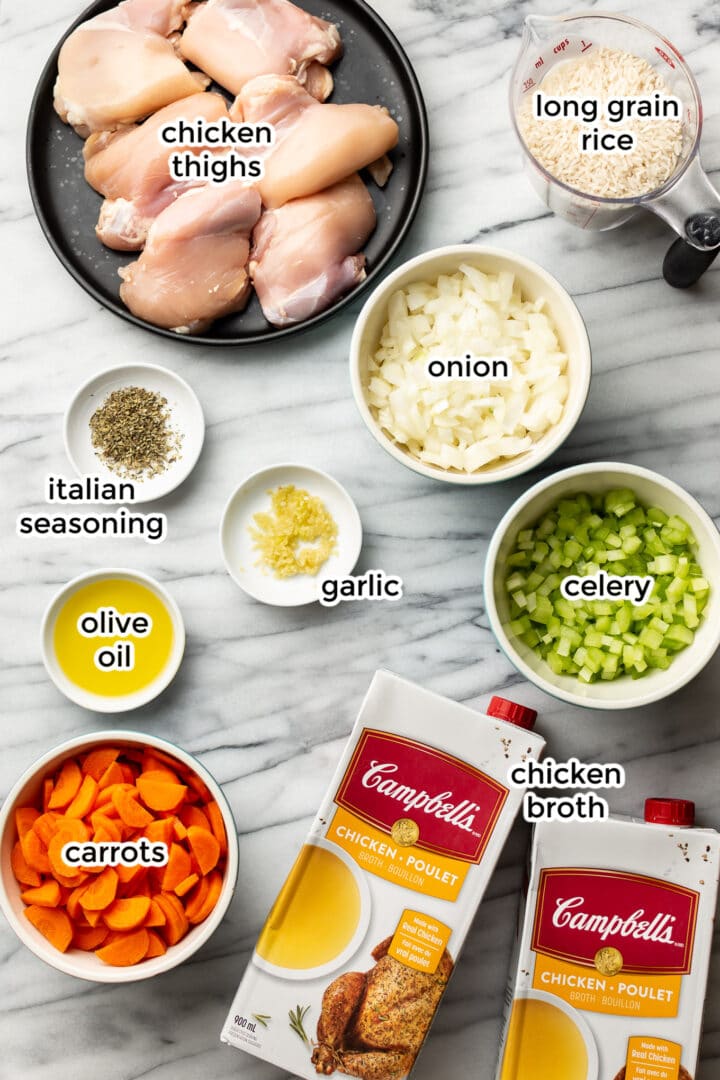 ingredients for chicken and rice soup on a marble surface