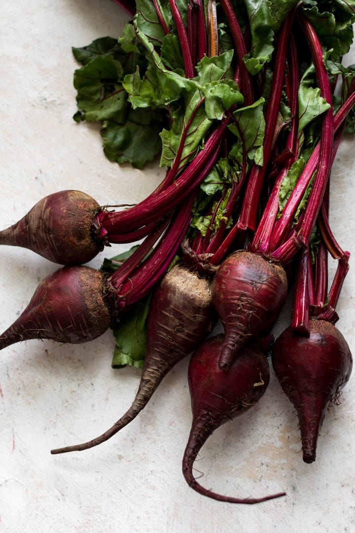 a bunch of several raw beets with stems