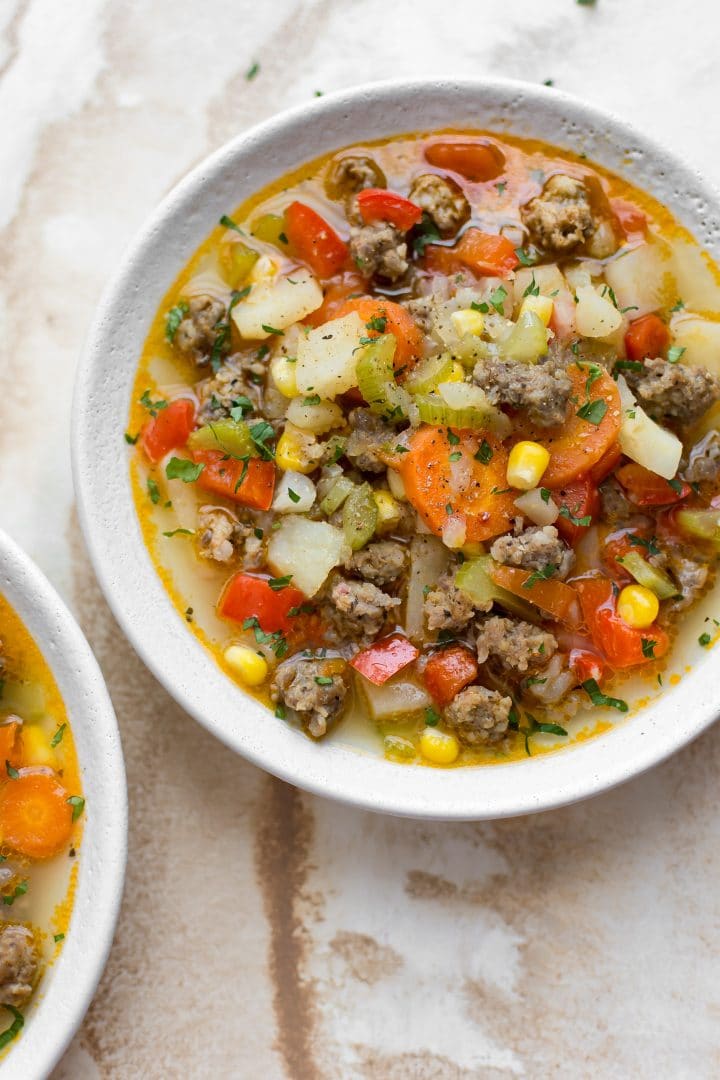 bowl of Italian sausage and vegetable soup in a white bowl