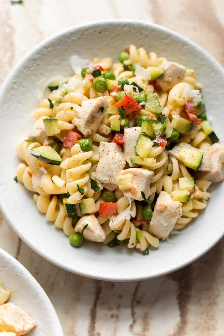 close-up of chicken pasta primavera in a white bowl