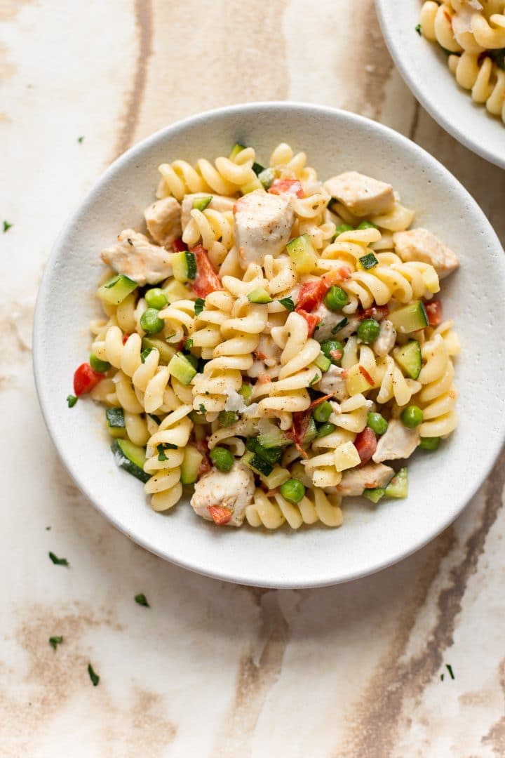 pasta with vegetables and chicken in a white bowl