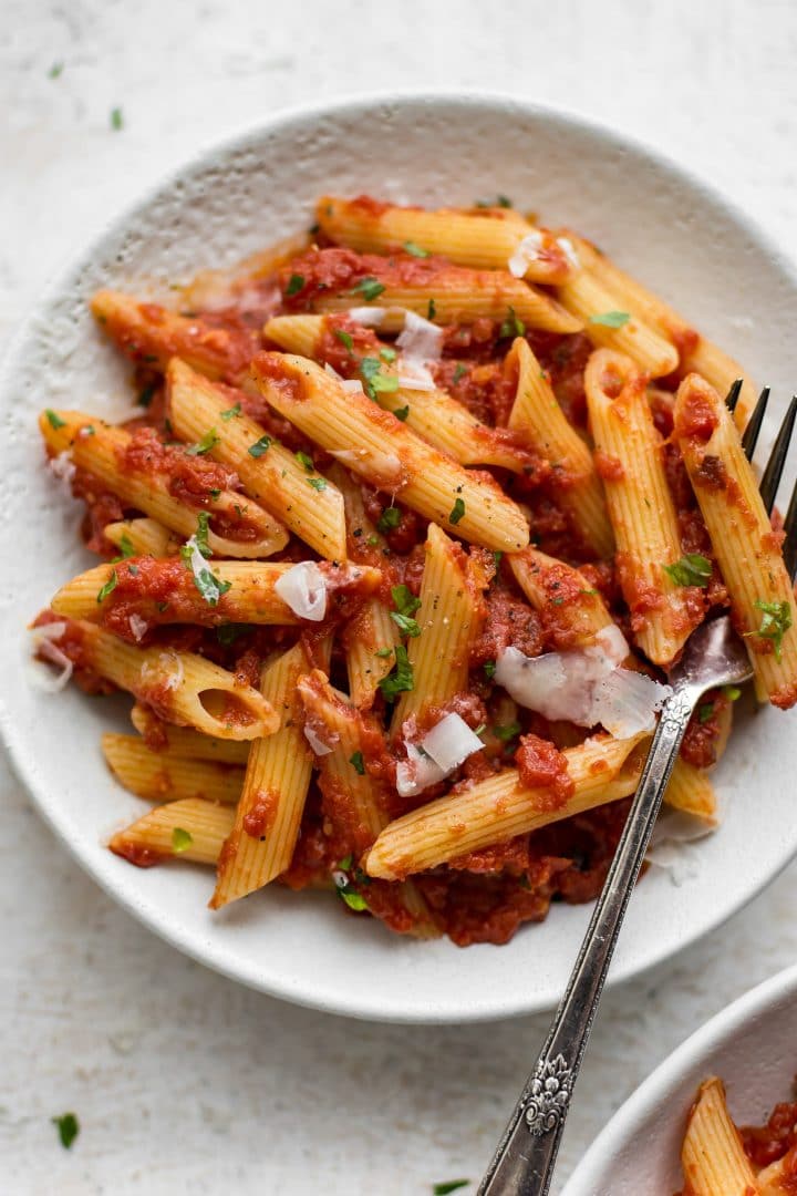 close-up of easy pasta arrabiata in a white bowl with a fork